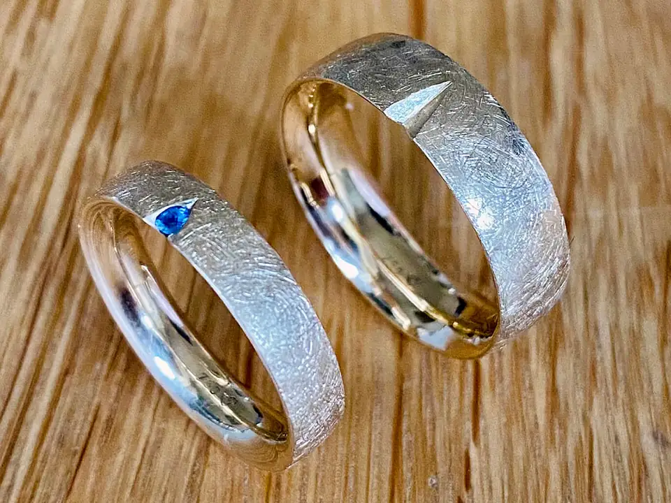 Zwei handgefertigte, strukturierte Goldringe, einer mit blauem Saphir
